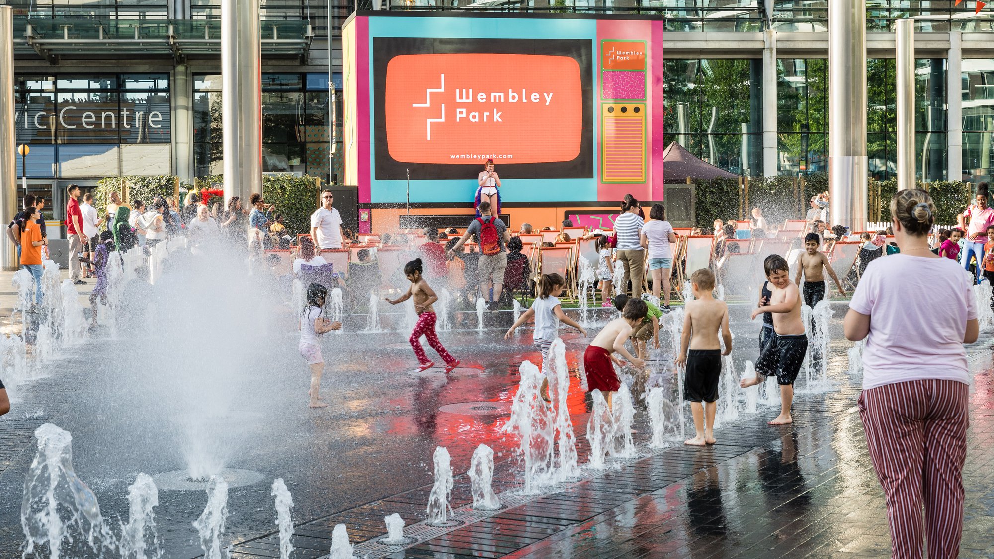 Children playing in the fountain at Summer on Screen in Wembley Park