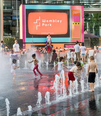 Children playing in the fountain at Summer on Screen in Wembley Park