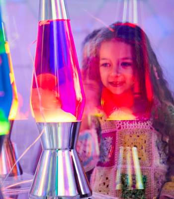 Child mesmerised by colourful lava lamps at Bubble Planet London, Wembley Park