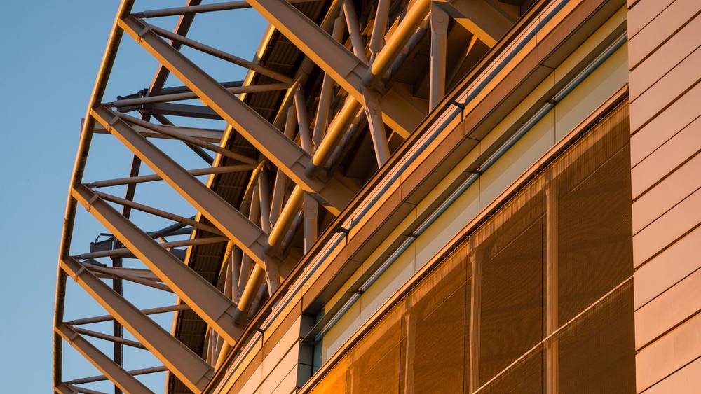 Wembley Stadium arch and glass facade glowing in warm sunset light – architectural detail for FA Cup Final 2026. Photo: Chris Winter