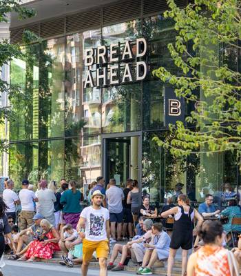 Crowds outside Bread Ahead bakery on Olympic Way Wembley Park near OVO Arena Wembley