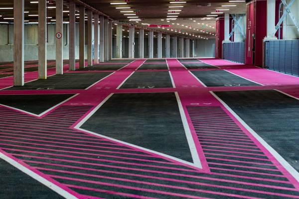 Interior view of Pink Parking at Wembley Park showing spacious parking bays with distinctive pink and black diagonal striped road markings, white bord