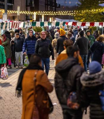 Crowds enjoying the Wembley Park Festive Market surrounded by Christmas lights and decorations.